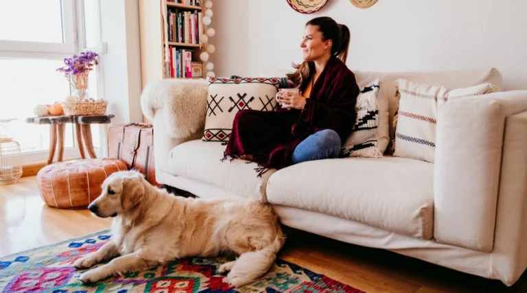 woman relaxing on sofa with dog