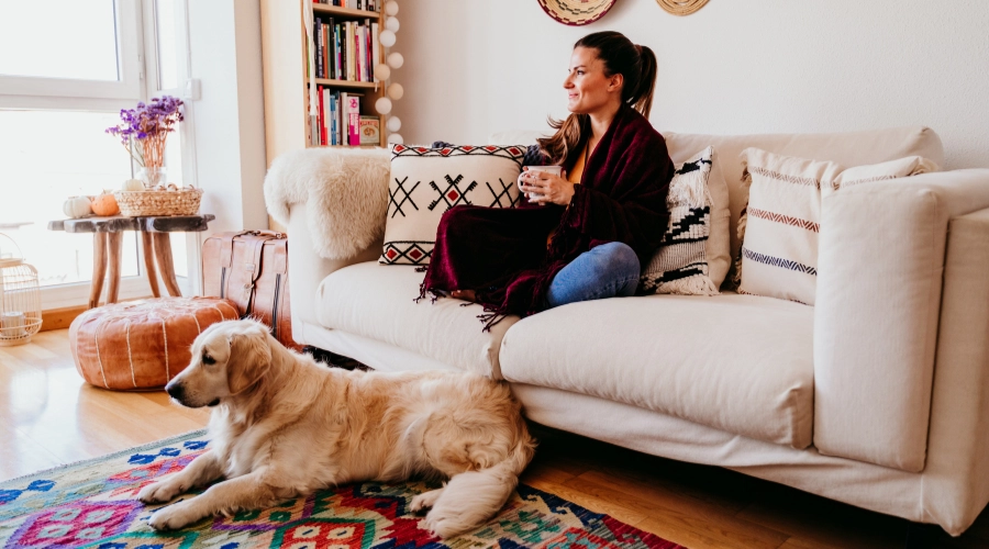 woman relaxing on sofa with dog